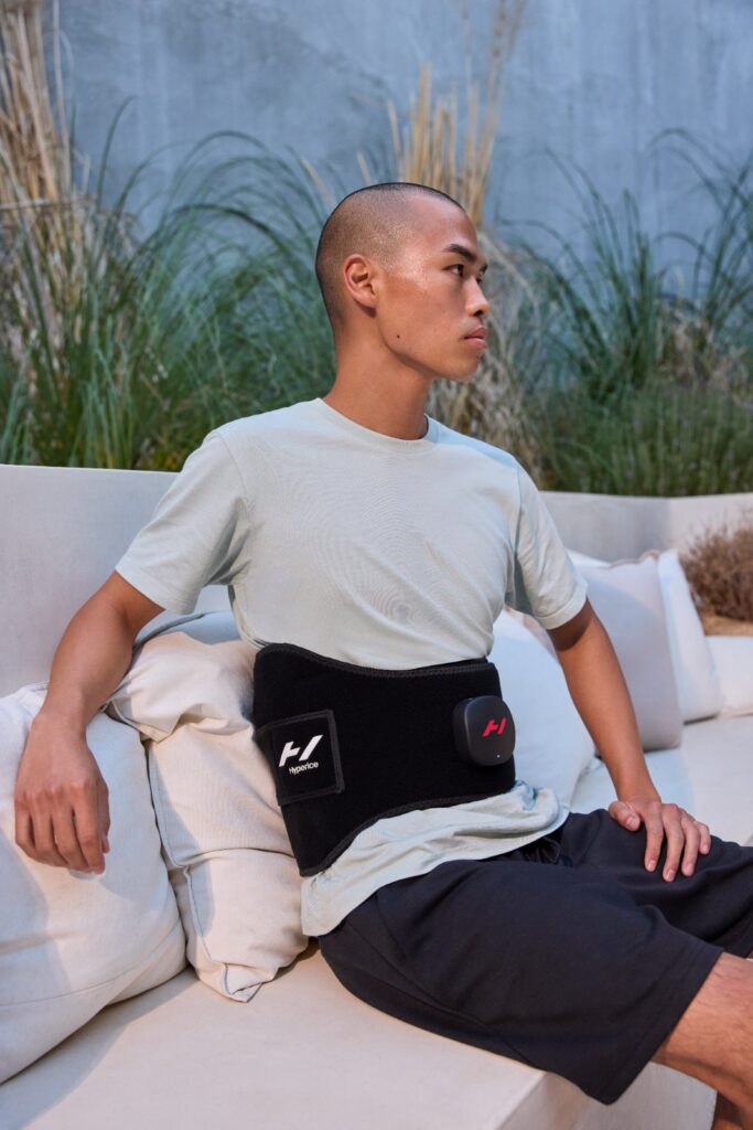 Hyperice Venom 2 Back heated massage wrap in use on the lower back